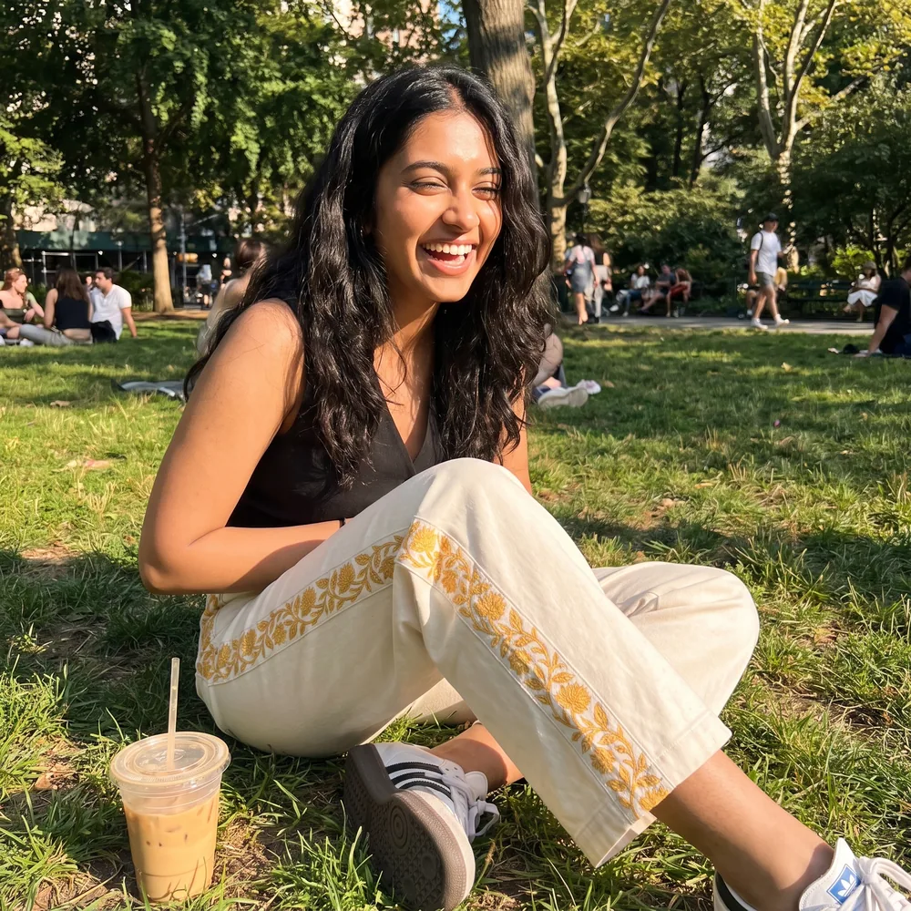 A customer in the Marigold Trouser sitting in a park